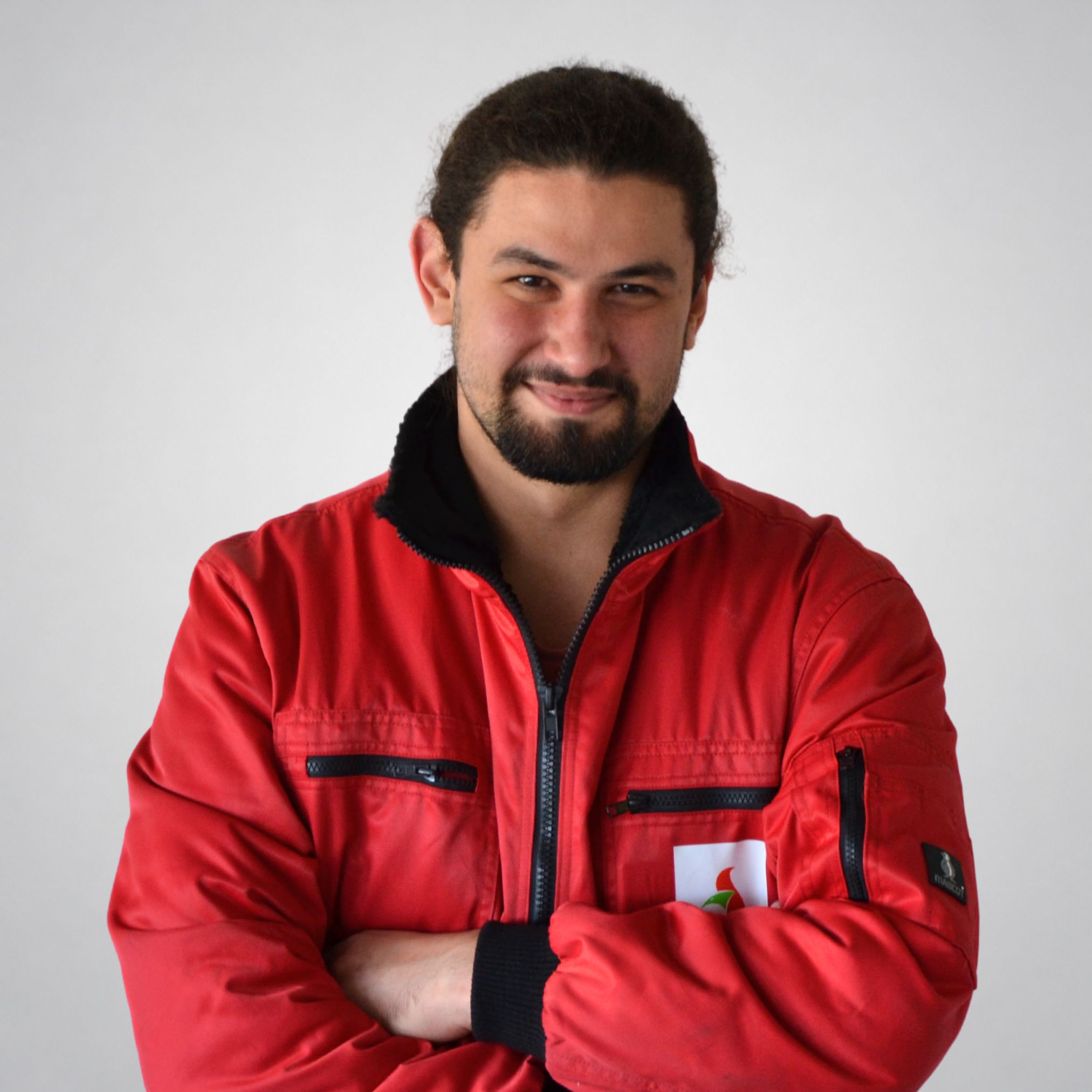 Ein Mann in roter Jacke lächelt.
