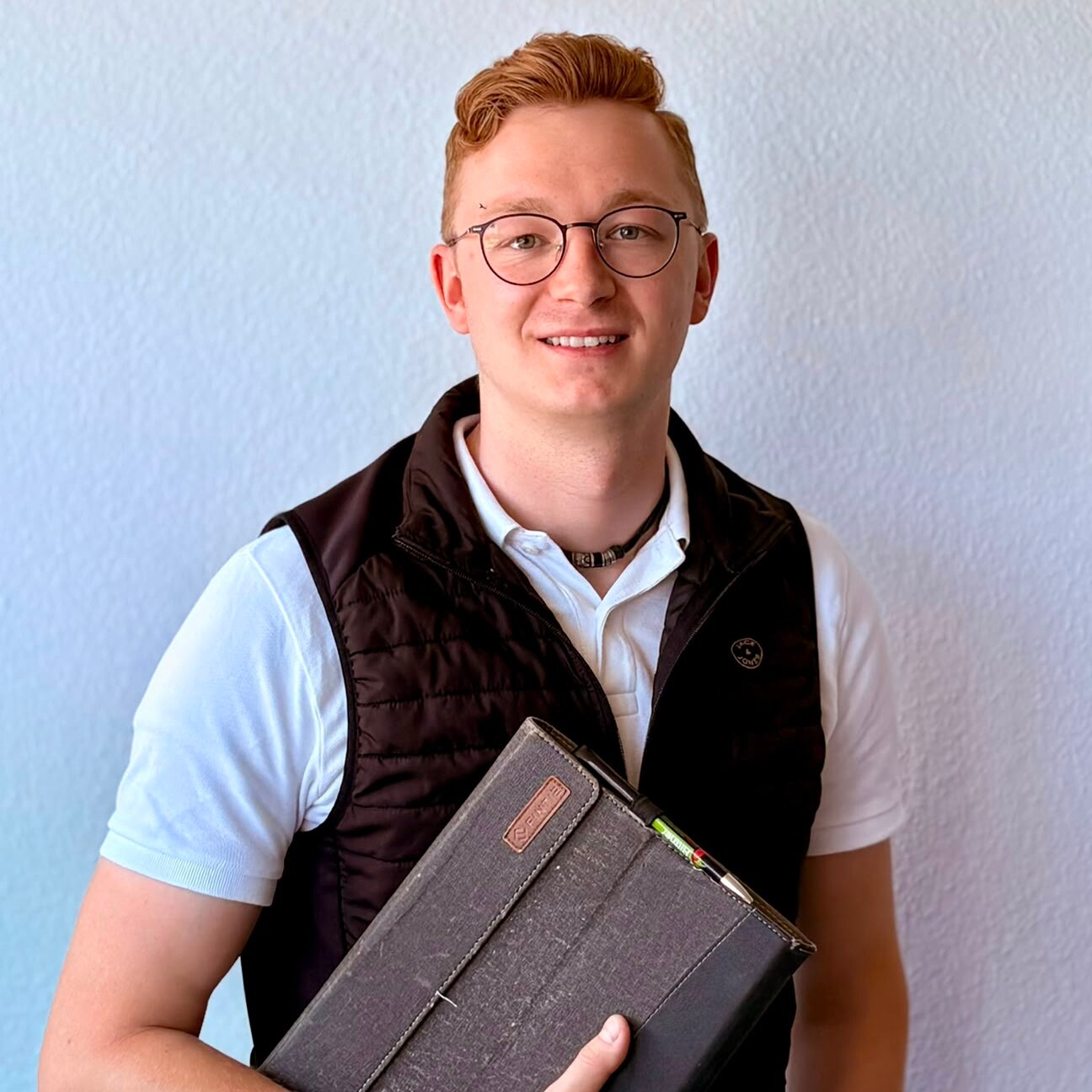 Vertrieb Ein Mann mit Brille und schwarzer Weste.