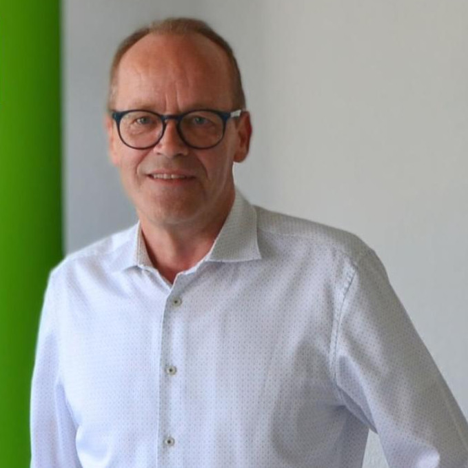 Ein Mann in einem weißen Hemd mit Brille.