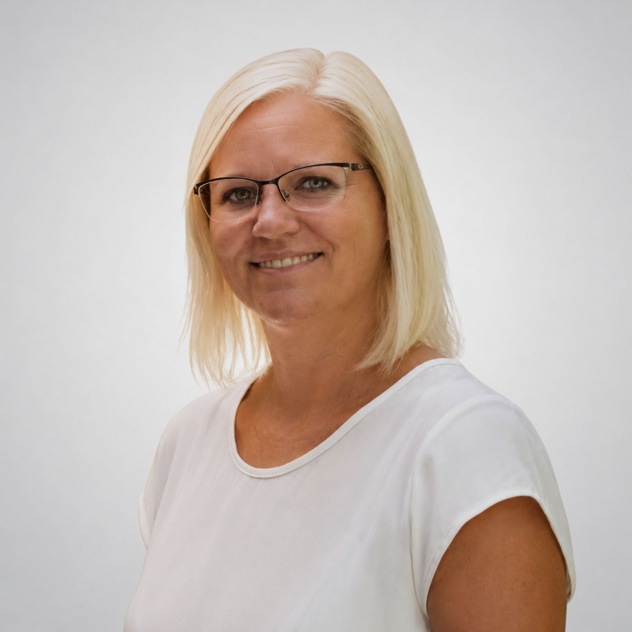Eine lächelnde Frau mit Brille.