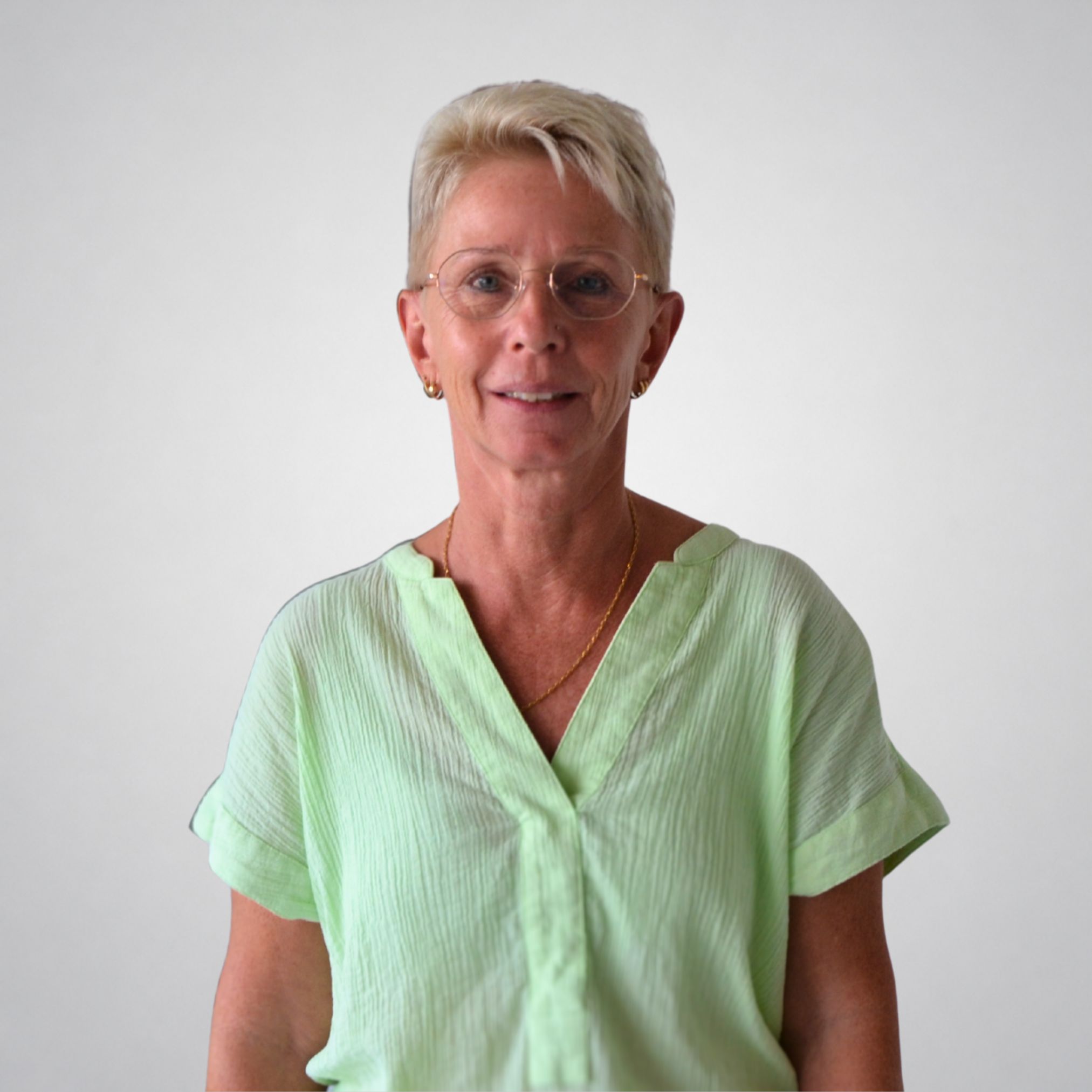 Eine Frau mit kurzen Haaren und Brille.