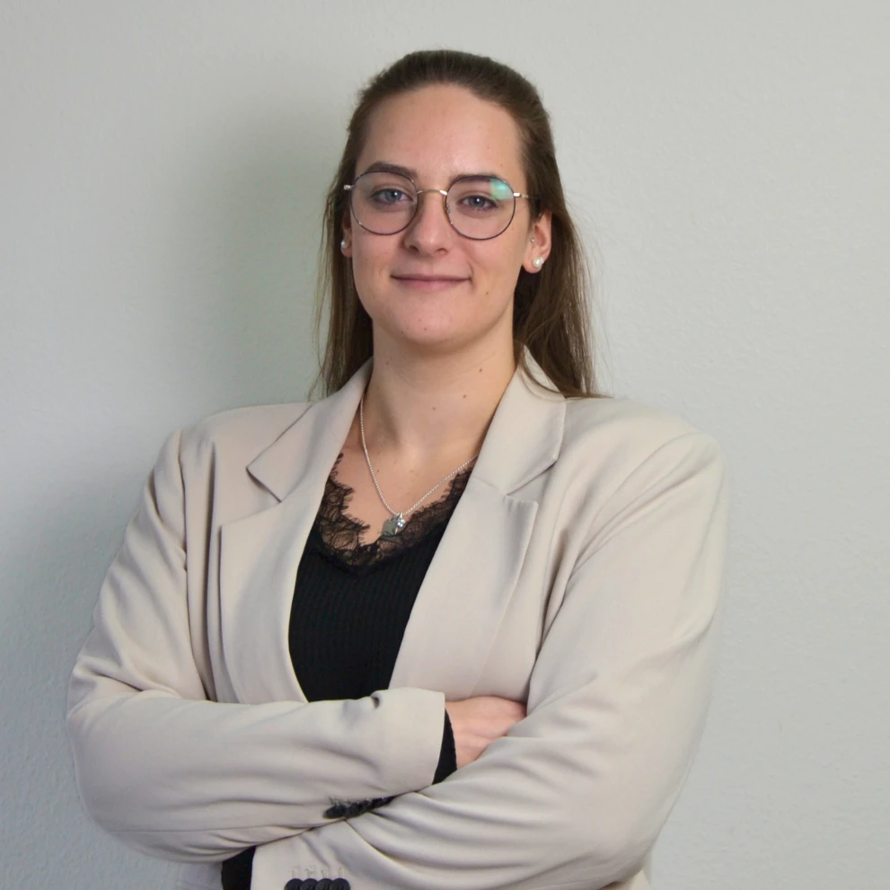 Eine Frau mit Brille und braunem Hemd.