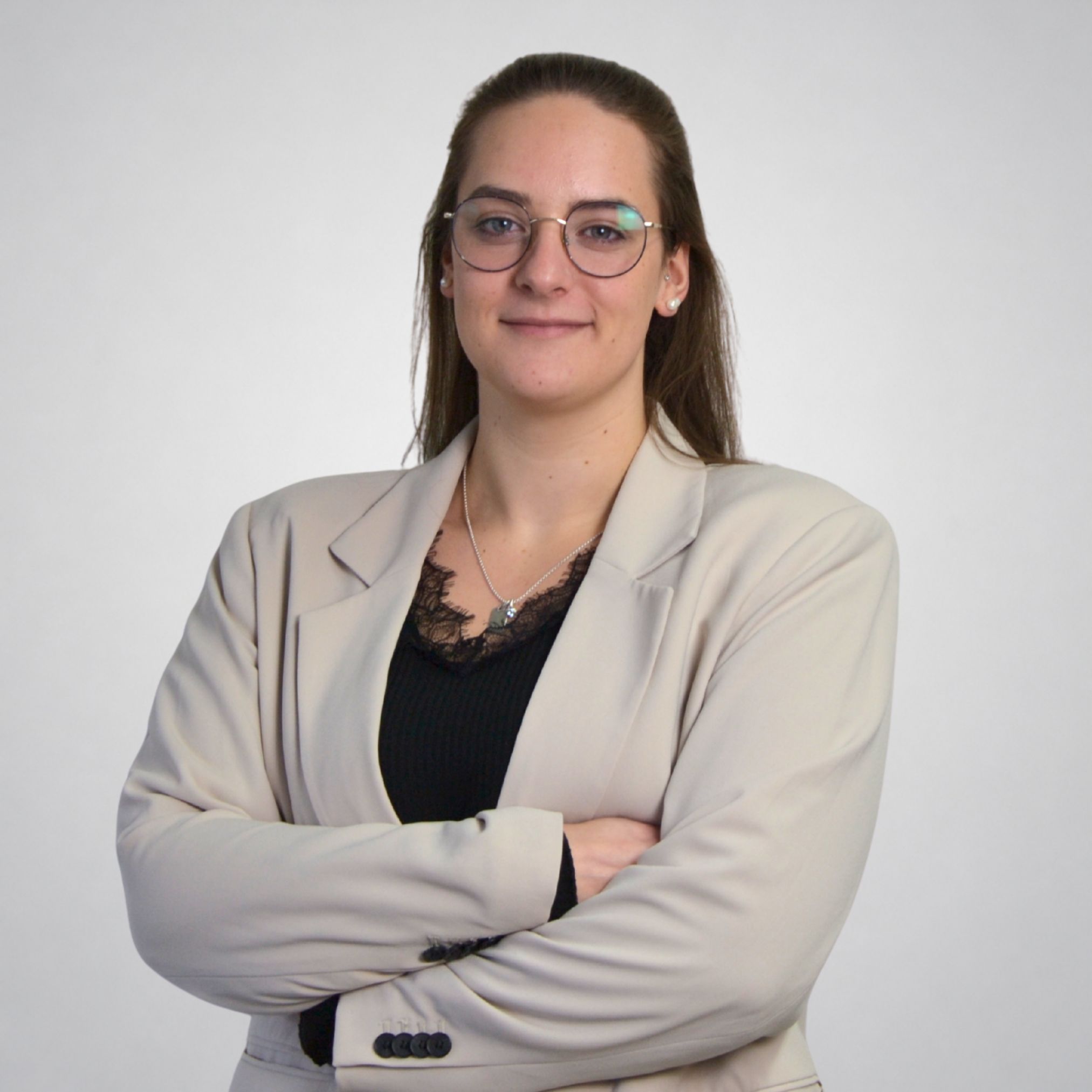 Eine Frau mit Brille und braunem Hemd.